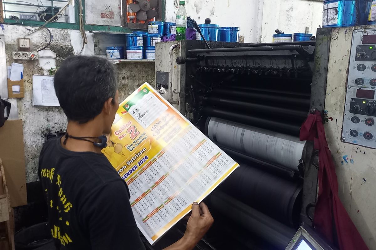 pegawai percetakan saat mengecek hasil cetak dari mesin, Senin (20/11/2023)