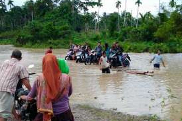 Warga melintas menaiki rakit di lokasi banjir Desa Rayeuk Pange, Kecamatan Pirak Timu, Aceh Utara, Selasa (9/2/2016)