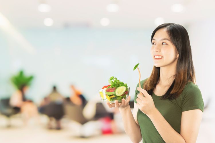 Ilustrasi wanita memakan makanan sehat.