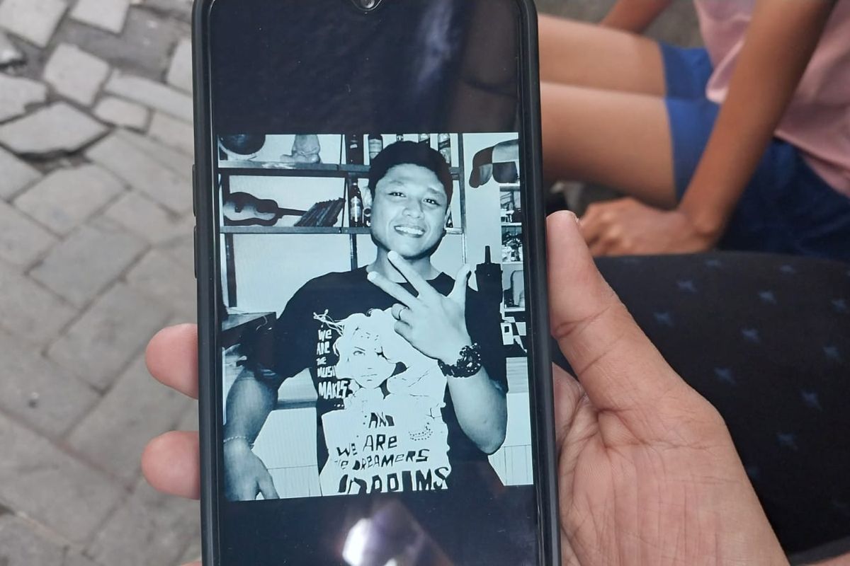 Ayu Komang (31), menunjukkan foto suaminya, Kadek Pawarta (31), melalui ponsel di rumahnya di Jalan Nanga Utara, Kota Denpasar, Bali, pada Selasa (18/2/2025). Kadek merupakan korban pembunuhan oleh tersangka Bastomi Prasetyawan alias Mas Pras, (38). 