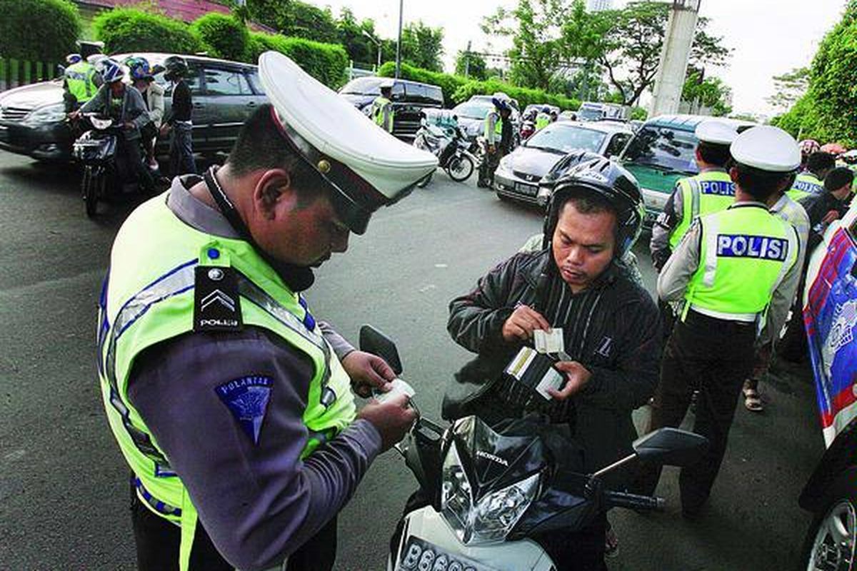 Pengendara sepeda motor dihentikan untuk pemeriksaan dalam rangka  Operasi Patuh Jaya di Jalan Gelora, Senayan, Jakarta, Kamis (21/7).