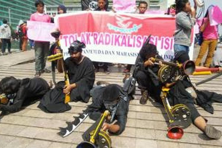 Mahasiswa dari Persatuan Pemuda Peduli Indonesia menggelar unjuk rasa damai menolak paham ISIS di kawasan Bundaran Hotel Indonesia pada Minggu (15/3/2015).
