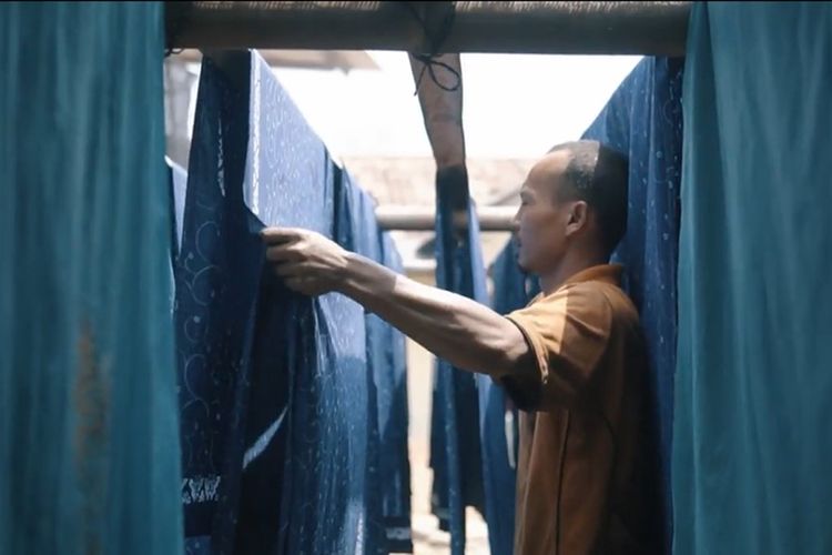 Seorang pekerja tengah mengerjakan pembuatan batik untuk seragam BCA