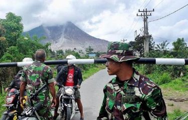 Petugas memperingatkan dua warga yang hendak keluar dari zona merah erupsi Sinabung di portal simpang Sibintun, Kecamatan Simpang Empat, Kabupaten Karo, Rabu (2/11/2016). Meskipun status Gunung Sinabung Awas dan potensi erupsi dan luncuran awan panas tinggi, peringatan untuk tidak beraktivitas di zona merah Sinabung masih terus dilanggar warga.
