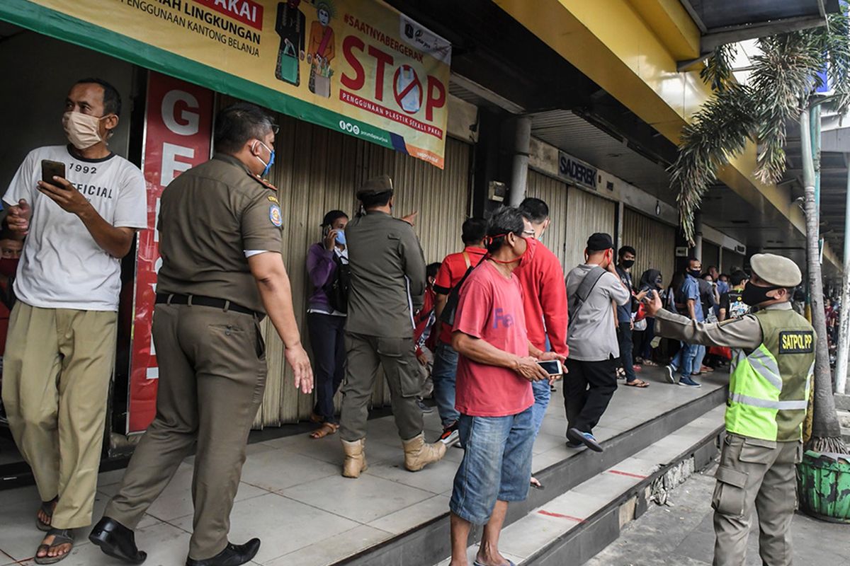 Petugas Satpol PP membubarkan aktivitas masyarakat di pusat pertokoan saat pemberlakuan Pembatasan Sosial Berskala Besar (PSBB) dalam rangka mencegah penyebaran COVID-19 di kawasan Glodok, Jakarta, Kamis (23/4/2020). Sejumlah toko yang buka dan tidak masuk pengecualian  dalam Pergub Nomor 33 Tahun 2020 terkait  pemberlakuan PSBB di Ibu Kota akan dilakukan tindakan tegas berupa tindak pidana ringan hingga pencabutan izin usaha.