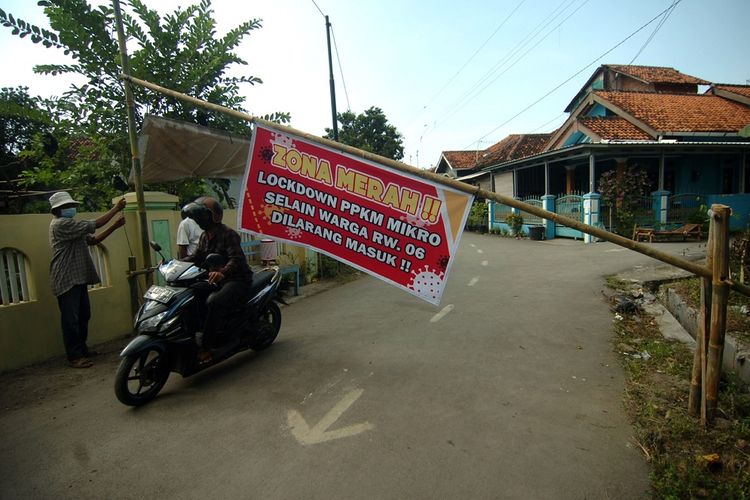 Satgas COVID-19 menjaga portal saat lockdown PPKM Mikro di RT 03 RW 06 Desa Balamoa, Kabupaten Tegal, Jawa Tengah, Jumat (18/6/2021). Sejak dua hari terakhir, desa tersebut melakukan karantina wilayah menyusul adanya 14 warga positif COVID-19 dari klaster hajatan dan satu diantaranya meninggal dunia. ANTARA FOTO/Oky Lukmansyah/rwa.