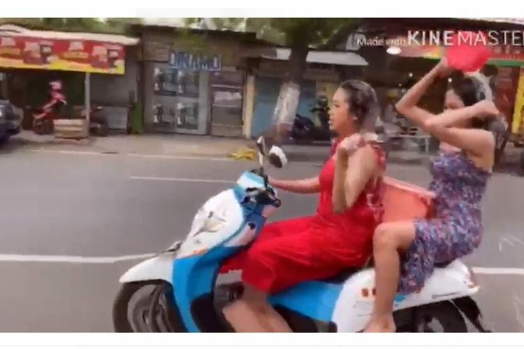 Tangkapan layar dari video aksi mandi keramas diatas motor yang dilakukan 2 wanita di Mojokerto, Jawa Timur.