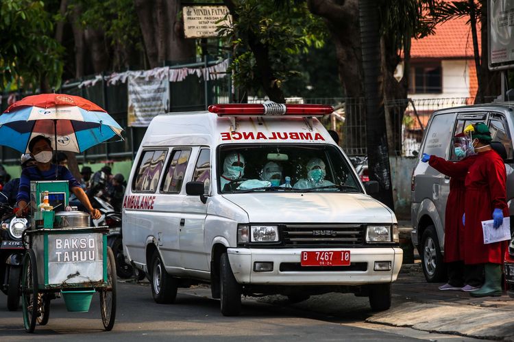 Petugas kesehatan menggunakan alat pelindung berada di mobil ambulans menuju Rumah Sakit Darurat Wisma Atlet untuk mengantar pasien positif Covid-19 orang tanpa gejala (OTG) di Puskesmas Kecamatan Tebet, Jakarta Selatan, Kamis (17/9/2020). Pemerintah Provinsi DKI Jakarta mengetatkan kembali pembatasan sosial berskala besar, per senin 14 september. Pasien positif Covid-19 tanpa gejala (orang tanpa gejala/OTG) yang sebelumnya bisa menjalani isolasi mandiri di rumah, saat ini harus dikarantina di tempat isolasi pemerintah, seperti di Rumah Sakit Darurat Wisma Atlet.