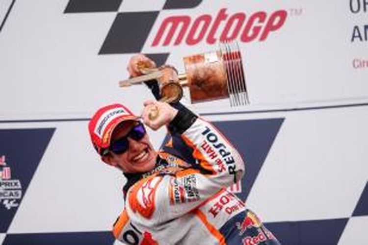 Pebalap Repsol Honda asal Spanyol, Marc Marquez, mengangkat trofi juara GP Americas di atas podium Sirkuit Americas, Austin, setelah finis pertama pada balapan Minggu (12/4/2015).