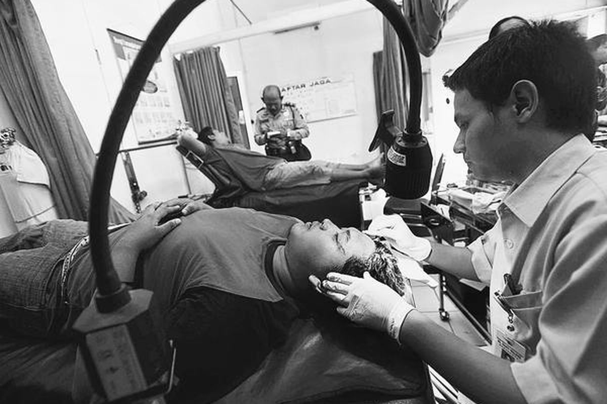 Wartawan foto Kantor Berita Antara, Hasan Sakri Ghozali (kiri), menjalani perawatan di RS Panti Waluyo, Solo, setelah kepalanya bocor karena dianiaya oleh suporter Persebaya Surabaya, Jumat (22/1). Hasan dianiaya di Stasiun Purwosari, Solo, saat meliput ribuan bonek dalam perjalanan menuju Bandung dengan KA Pasundan.