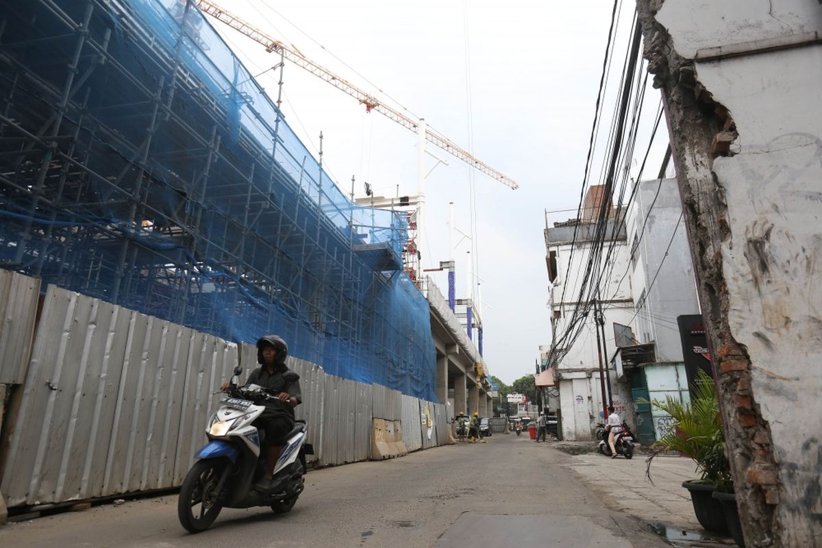 Sejumlah warga melintas di bawah proyek mass rapid transit (MRT), jalan Fatmawati, Jakarta Selatan, Senin (23/10/2017). 26 lahan di Jalan Fatmawati akan segera dibongkar untuk proyek pembangunan MRT, Proyek ini diperkirakan akan rampung pada tahun 2018.