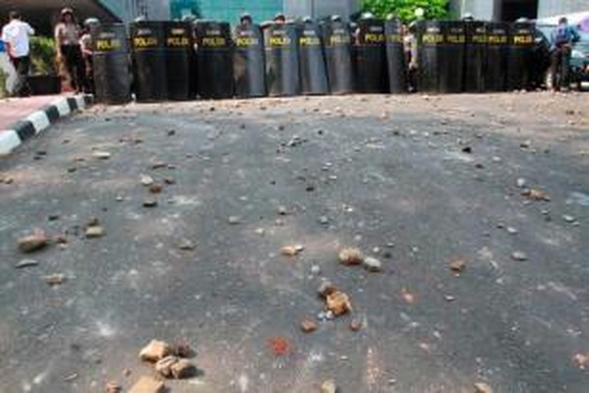 Polisi menghadapi massa Front Pembela Islam (FPI) yang melemparkan batu ke arah Gedung DPRD DKI Jakarta saat terjadi kerusuhan aksi unjuk rasa FPI, Jumat (3/10/2014). Massa FPI berdemo menolak Ahok diangkat menjadi Gubernur DKI Jakarta.