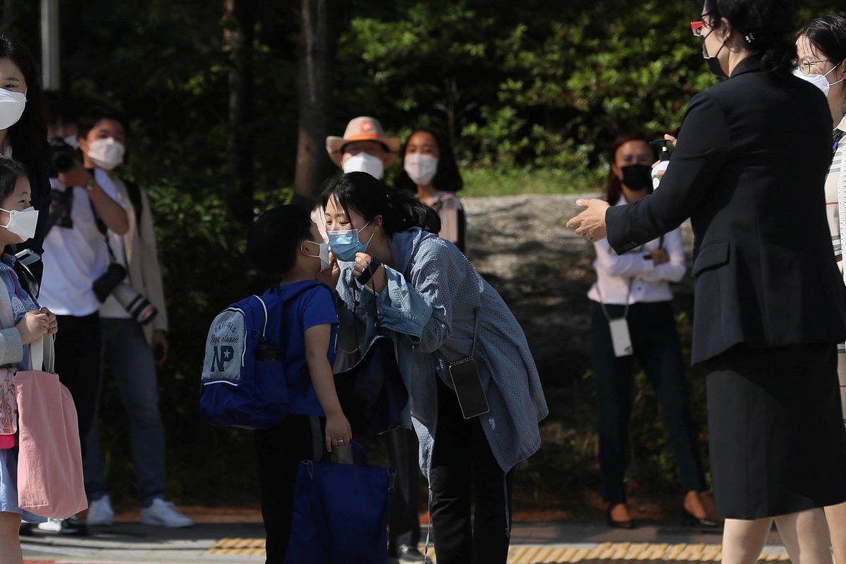 Seorang ibu mencium anaknya, di mana mereka menggunakan masker untuk menghindari penularan virus corona di TK di Seoul, Korea Selatan, pada 27 Mei 2020.