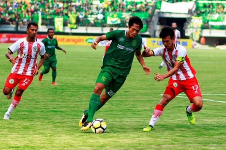 Penyerang Persebaya, Rishadi Fauzi mencoba melewati kapten Sarawak FA, Hairol Mokhtar (kanan) pada laga uji coba di Gelora Bung Tomo, Surabaya, Minggu (18/3/2018) sore.