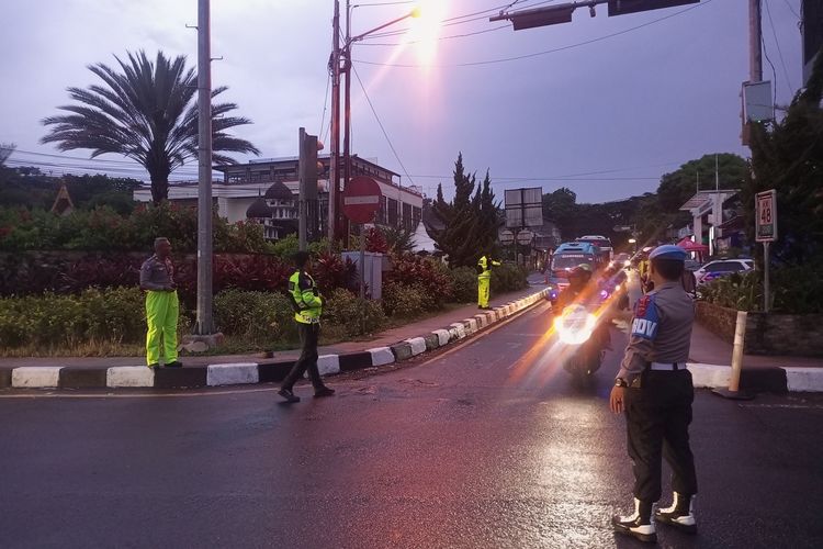 Petugas kepolisian sedang menormalkan arus lalu lintas setelah diberlakukan one way di ruas Jalan Raya Puncak Bogor, Jawa Barat, Minggu (23/4/2023).