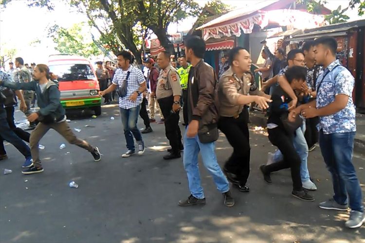 Polisi mengamankan seorang pengunjukrasa dalam aksi yang berujung ricuh di depan kantor Bupati Cianjur, Kamis (15/08/2019). Dalam aksi tersebut empat orang anggota polisi terluka karena mengalami luka bakar serius.