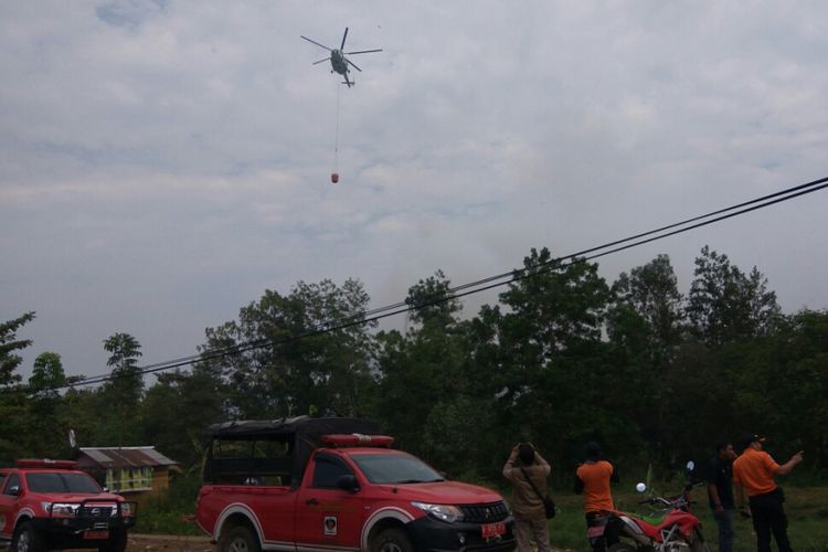 Helikopter water bombing milik BNPB saat berupaya membantu memadamkan kebakaran lahan gambut yang terjadi di belakang Fakultas Kedokteran Universitas Tanjungpura, Jalan Sepakat II, Pontianak (23/8/2018)