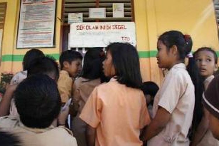 Sejumlah siswa SD Negeri 64 Ambon hanya bisa melihat sekolah mereka disegel, Sabtu (11/4/2015). penyegelan ini membuat para siswa terpaksa tidak bisa belajar di sekolahnya 