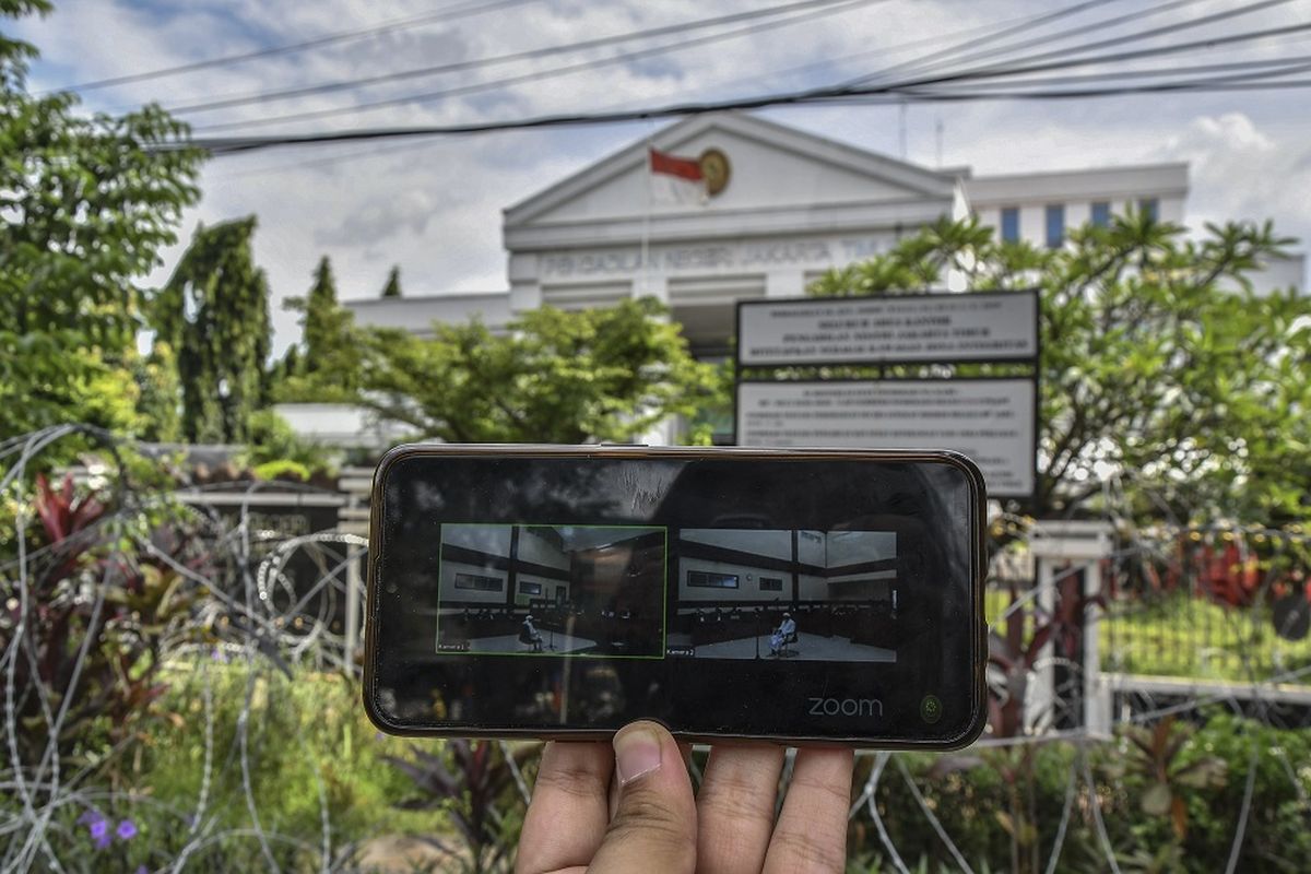 Layar telepon pintar menampilkan suasana sidang kasus pelanggaran protokol kesehatan dengan terdakwa Rizieq Shihab yang digelar secara virtual di PN Jakarta Timur, Selasa (6/4/2021). Rizieq Shihab kembali dsidangkan dengan agenda putusan sela untuk dua perkara yaitu kerumunan di Petamburan, Jakarta Pusat dan Kerumunan di Megamendung, Jawa Barat. ANTARA FOTO/ Fakhri Hermansyah/foc.