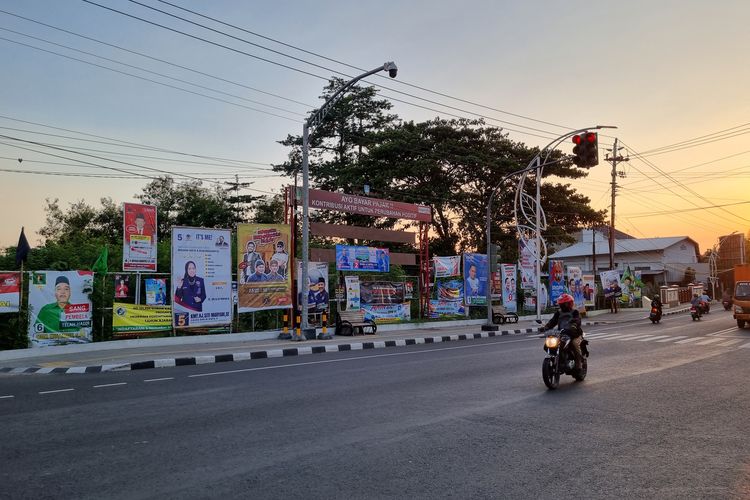 Pengendara sepeda motor melintas di pertigaan yang dipenuhi poster kampanye calon legislatif (caleg) Jl. Ir. Juanda, Kelurahan Pucangsawit, Kecamatan Jebres, Solo, (Jumat 22/12/2023).