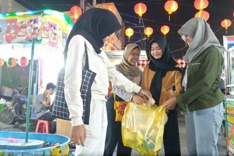 Empat gadis begitu semangat mengumpulkan sampah di Kompleks Pasar Gede Surakarta, Rabu (22/1/2020) malam. 