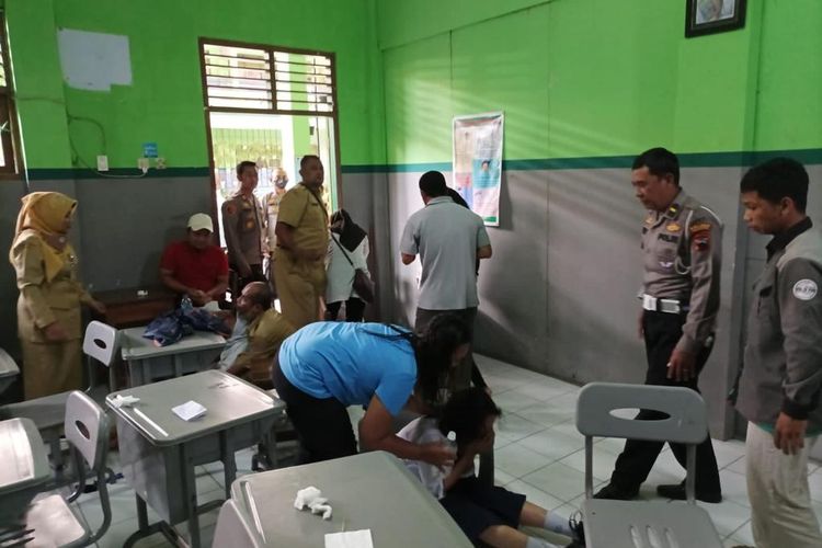 Siswa yang mengalami kesurupan ditenangkan oleh polisi dan ahli spiritual.