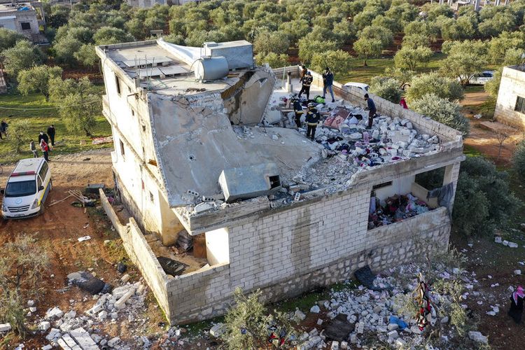 Orang-orang memeriksa rumah yang hancur menyusul operasi militer AS di desa Atmeh, Suriah, di provinsi Idlib, Suriah, Kamis, 3 Februari 2022. 