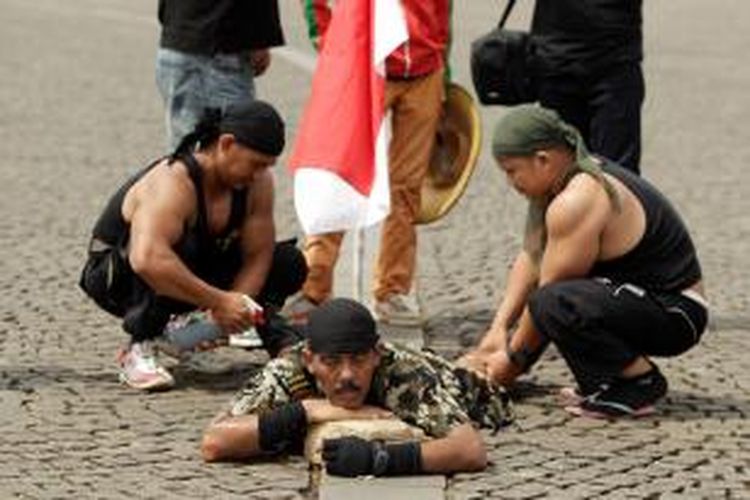 Kopral Bagyo beristirahat sejenak saat berjalan memutari Tugu Monumen Nasional di Jakarta, Sabtu (06/07/2013). Kopral Bagyo berencana untuk memutari monas selama 25 jam dalam rangka hari ulang tahun Polisi Militer dan kampanye hidup sehat tanpa narkoba. 