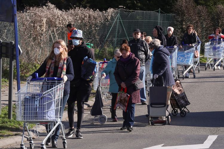 Para pengunjung mengantre di luar supermarket sebelum pemerintah Belgia menerapkan lockdown untuk melawan virus corona pada 18 Maret 2020 siang waktu setempat.