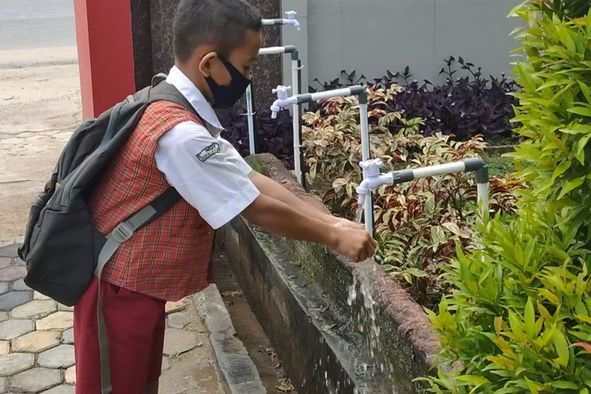 1. Siswa baru SMP Negeri 1 Indralaya Ogan Ilir dengan menggunakan masker berbaris dengan menjaga jarak sebelum masuk ke dalam kelas

2. Salah satu siswa mencuci tangan sebelum masuk ke dalam lingkungan sekolah di SMP Negeri 1 Indralaya Ogan Ilir