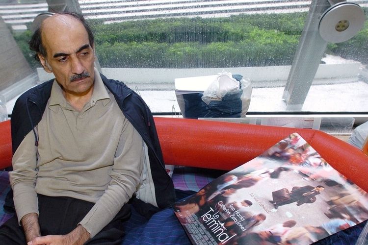 Mehran Karimi Nasseri memperhatikan poster film The Terminal yang terinspirasi dari kisah hidupnya terlunta-lunta di Bandara Charles De Gaulle, Prancis, 12 Agustus 2004. Nasseri meninggal pada Sabtu, 12 November 2022 di bandara itu. 