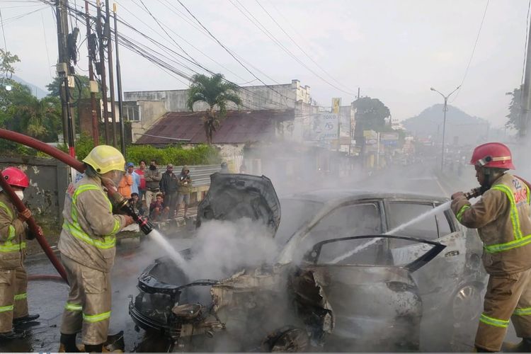 Personel pemadam kebakaran saat melakukan proses pemadaman pada satu unit mobil terbakar pasca menabrak tembok jembatan di Kecamatan Lawang, Kabupaten Malang, Selasa (15/11/2022).