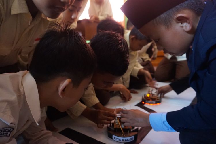 Laist, siswa kelas 1 SMP Pondok Pesantren Internasional Science anda Technology  menunjukkan robot rakitannya kepada siswa kelas 6 SD Muhammadiyah 1 Banyuwangi Rabu (31/1/2018). 