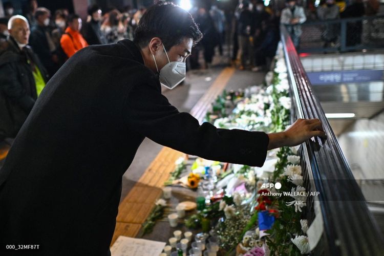 Seorang pria meninggalkan pesan di peringatan darurat di luar stasiun kereta bawah tanah Itaewon di distrik Itaewon di Seoul pada 30 Oktober 2022, sehari setelah penyerbuan Halloween di daerah tersebut.