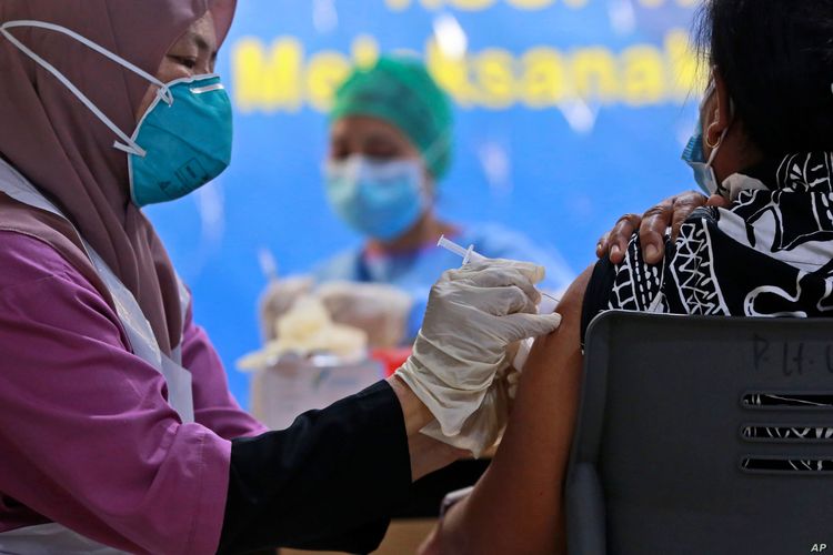 A health worker gives a jab of the Sinovac COVID-19 vaccine to a woman during a vaccination campaign at the Adam Malik Hospital in Medan, North Sumatra, Indonesia (30/6/2021)
