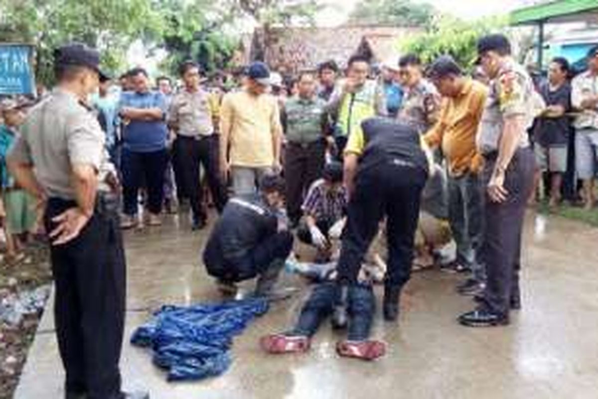 Sejumlah aparat Kepolisian berusaha mengidentifikasi pemuda tanpa identitas yang ditemukan tewas bersimbah darah di Jalan Raya Kampung Cabang Empat RT 02/01, Desa Huripjaya, Kecamatan Babelan, Kabupaten Bekasi pada Rabu (26/10/2016) pukul 02.00 WIB.