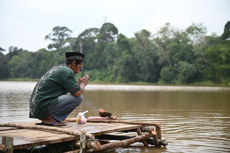 Datuk Mangku Setio Alam sedang menjalani prosesi penetapan lubuk larangan, pengambilan sumpah di Danau Riak Tembakang, sebagai sebuah kearifan lokal yang hidup selaras dengan alam. Dalam kegiatan itu juga ada pelepasan bibit ikan dari tim Ekspedisi Batanghari