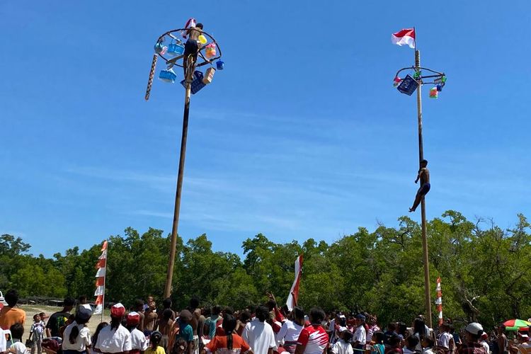 Peserta upacara hari kemerdekaan mengikuti perlombaan panjat pinang yang digelar di pesisir Pantai Motaain, Silawan, Belu, Nusa Tenggara Timur (NTT), Kamis (17/8/2023).  
