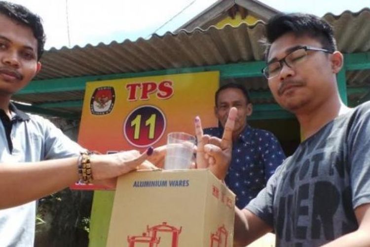 Warga menunjukkan hadiah panci usai menggunakan hal pilihnya pada Pilkada Kabupaten Brebes di TPS 11, RW 006, Kelurahan Kaligangsa Kulon, Rabu (15/7/2017). 