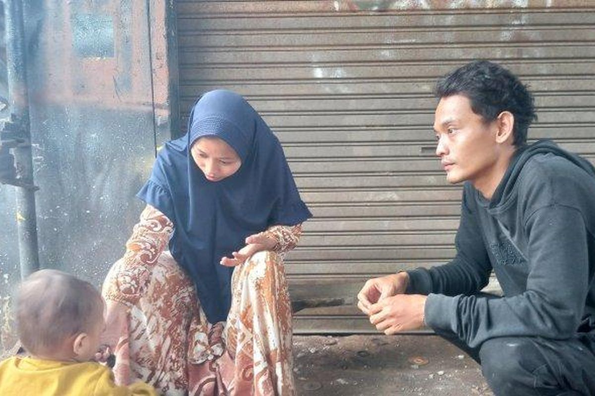 Sudirman Soleh (27) dan Iis Santi (20) asal kampung Cisarua, RT.02, RW.03, Desa Sarampad, Kecamatan Cugenang, Kabupaten Cianjur terpaksa makan satu nasi bungkus dengan anaknya karena belum ada bantuan makanan dan minuman, Kamis (24/11/2022).