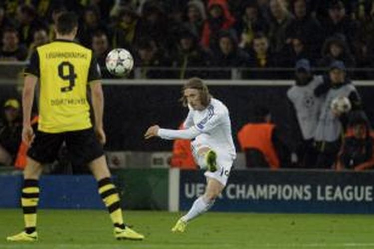 Gelandang Real Madrid, Luka Modric (tengah), melakukan tendangan dan striker Borussia Dortmund, Robert Lewandowski, hanya melihatnya, ketika kedua tim bertemu di leg kedua babak perempat final Liga Champions di Signal Iduna Park, Selasa (8/4/2014).