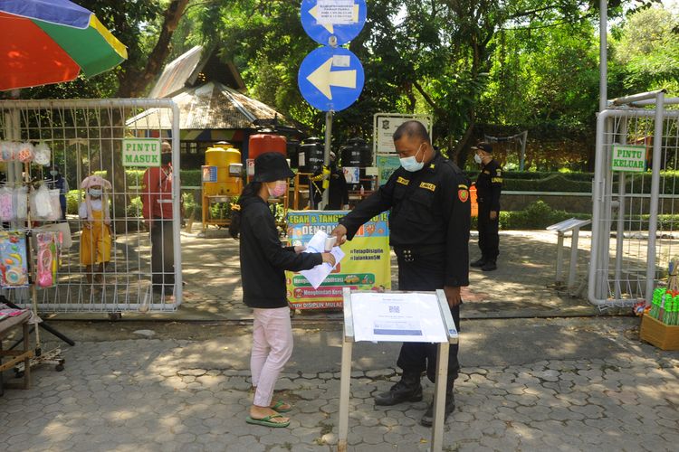Petugas dari BPB Linmas Kota Surabaya saat melakukan screening terhadap pengunjung di Taman Flora, Surabaya, Jumat (22/10/2021).