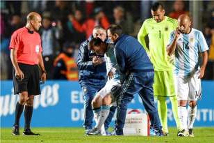 Tim medis Barcelona menuntun Lionel Messi keluar lapangan saat Argentina melawan Honduras pada partai uji coba di Stadion San Juan del Bcentenario, Jumat (27/5/2016).