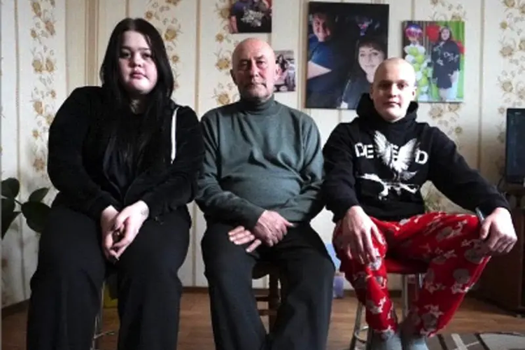 Dima (kanan) dan kakak perempuannya Daryna (kiri) kini diasuh oleh kakek mereka Valeriy Kozyr (tengah).