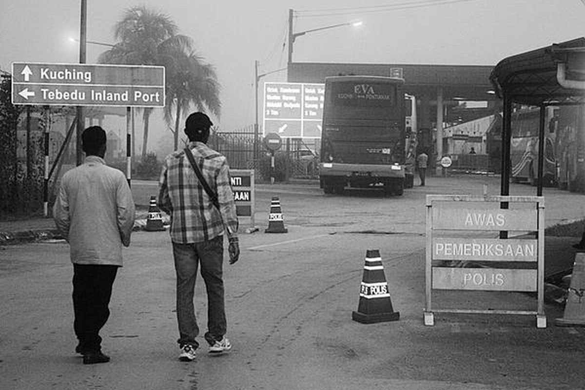 Suasana pagi hari saat pintu perbatasan Tebedu, Sarawak, Malaysia, yang bersempadan dengan Pos Lintas Batas Entikong, Kabupaten Sanggau, Kalimantan Barat, dibuka. Sebagian besar warga Indonesia yang mencari kerja di Sarawak melintas pada pagi hari.