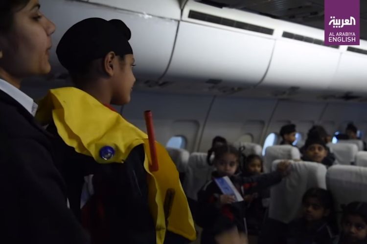Anak-anak mendengarkan penjelasan penggunaan jaket pelampung, saat mengunjungi wahana simulasi penumpang pesawat di India.