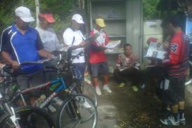 Beberapa penghobi sepeda saat membaca koleksi buku di perpustakaan sepeda di kawasan bukit Lebak Tumpang, Kelurahan Pojok, Kecamatan Mojoroto, Kota Kediri, Jawa Timur, Sabtu (14/12/2013).