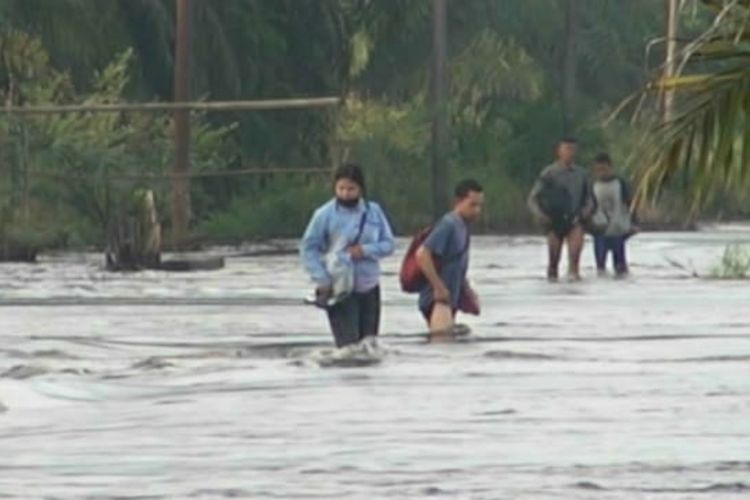 Sejumlah warga dari Desa Buluh Cina, Kecamatan Siak Hulu, Kabupaten Kampar, Riau, berjuang menerobos arus banjir yang deras untuk beraktivitas, Sabtu (21/12/2019).