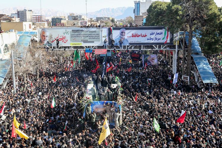 Para pelayat berkumpul di sekitar kendaraan yang membawa peti jenazah Jenderal Qasem Soleimani di Kerman, Iran, pada 7 Januari 2020. Soleimani tewas setelah mobil yang ditumpanginya diserang AS di Bandara Internasional Baghdad, Irak, pada 3 Januari 2020.