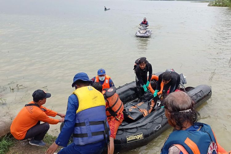 Para personel tim gabungan pada saat melakukan evakuasi jasad korban perahu terbalik di Waduk Gondang, Lamongan, menuju ke daratan, Senin (7/2/2022).